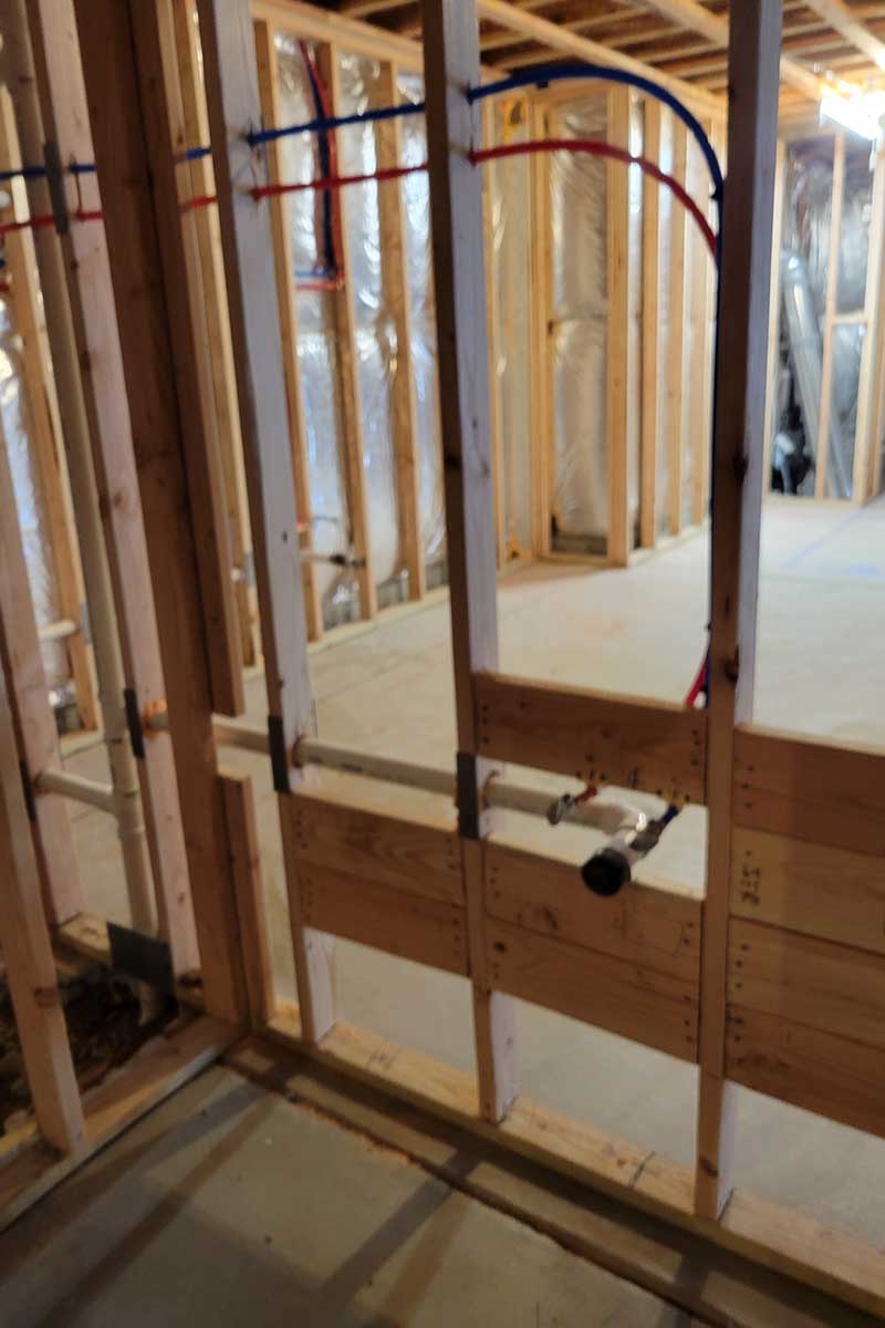 Totally Plumbing - Rough plumbing installation including an ejector tank for a full bathroom with a stall shower and bar sink in a finished basement - Monroe, New Jersey – March 2022