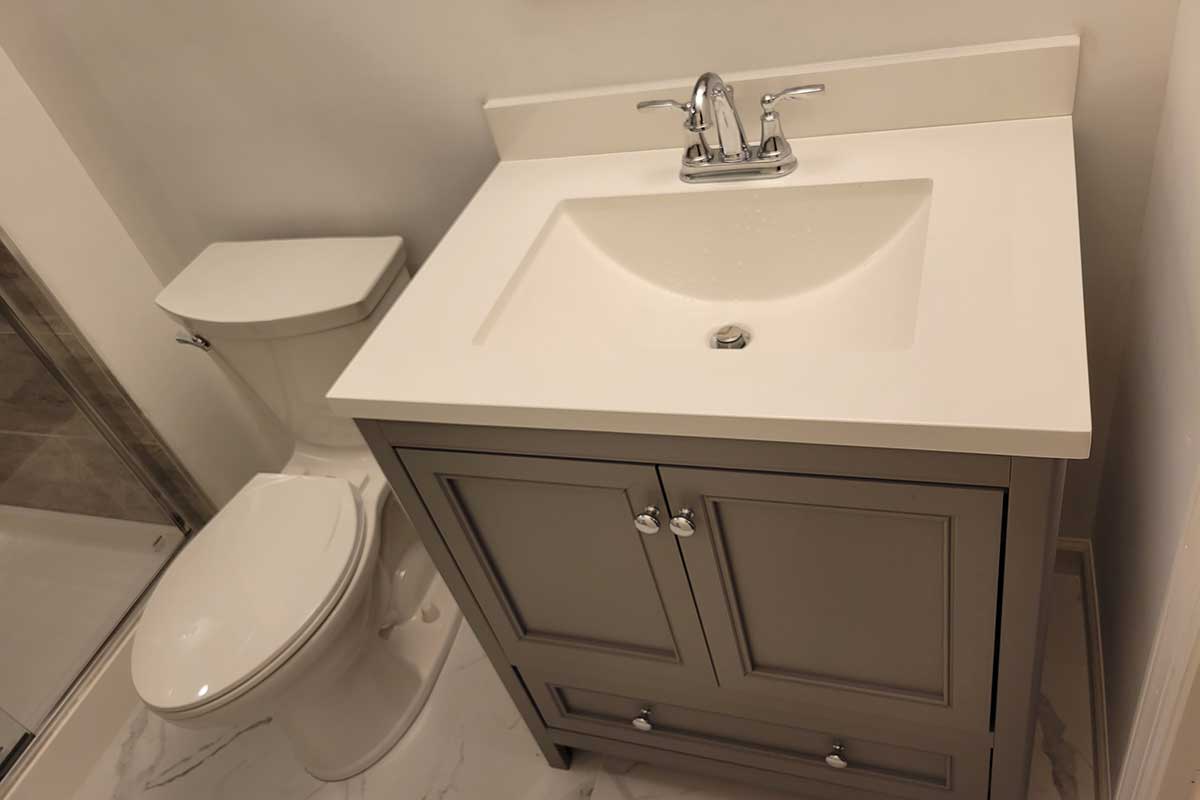 Totally Plumbing - Finished plumbing installation including sink, faucet, toilet, stall shower, and shower trim for a full bathroom in a finished basement in Voorhees, New Jersey – March 2022