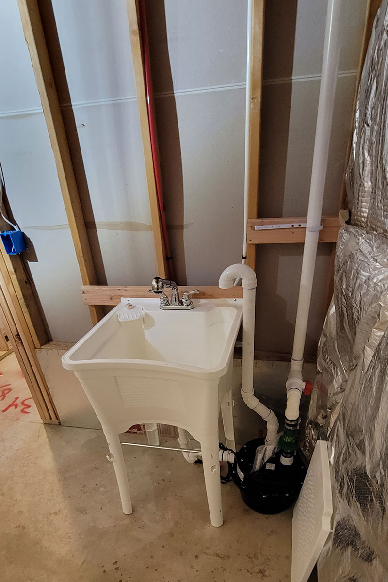 Totally Plumbing - Rough plumbing and finished plumbing installations including a laundry sink, water lines, and ejector tank in a finished basement - Mount Royal, New Jersey – July 2022
