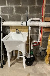Totally Plumbing - Rough plumbing and finished plumbing installations including a laundry sink, water lines, and ejector tank in a basement - Chester, New Jersey – June 2023